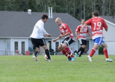 Players competing for the ball at Telkwa BBQ Grounds Park