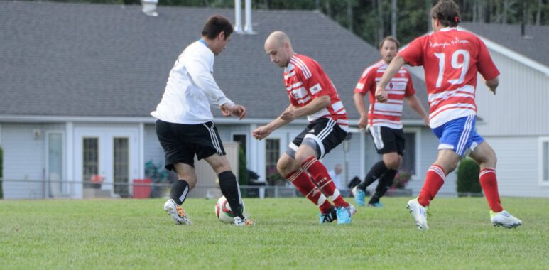 Players competing for the ball at Telkwa BBQ Grounds Park
